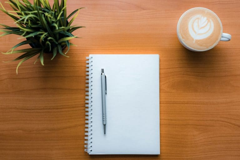 A blank notebook with a coffee - perfect for sabbatical proposal work.