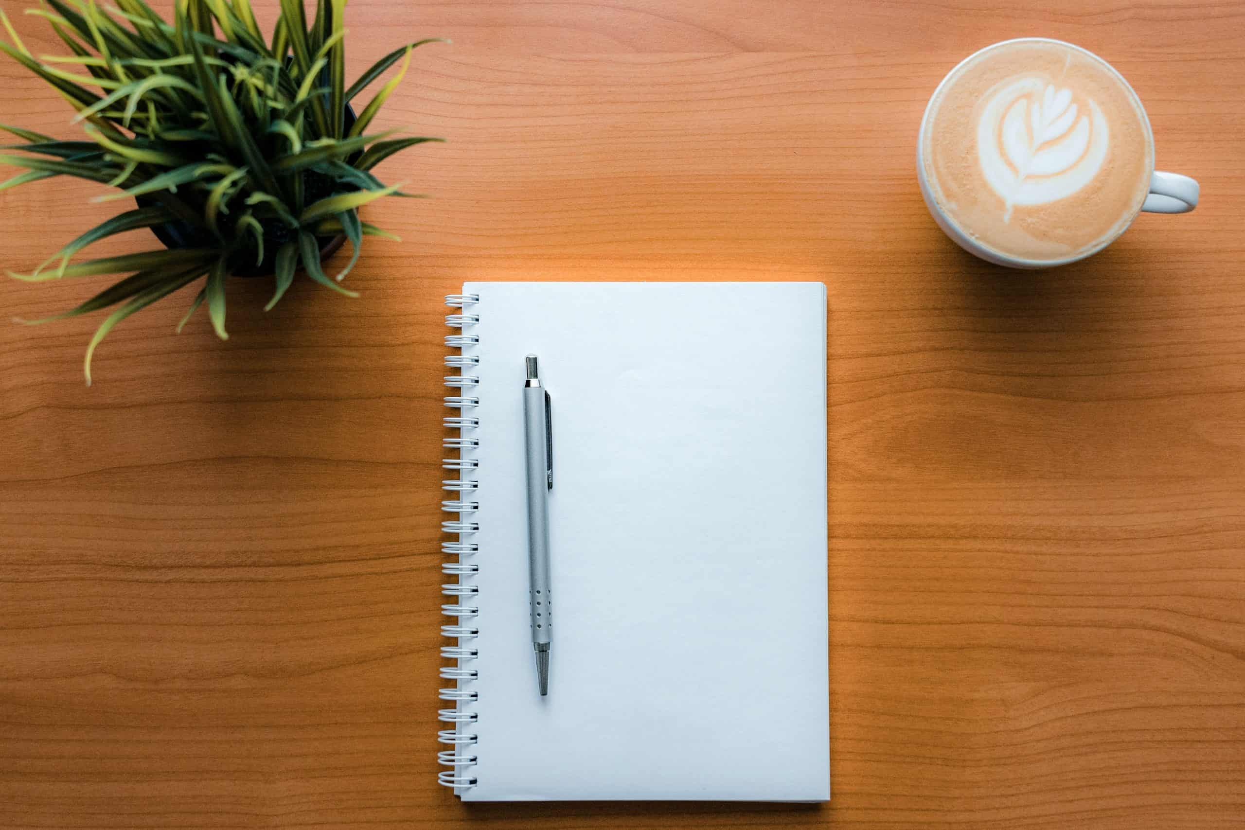 A blank notebook with a coffee - perfect for sabbatical proposal work.